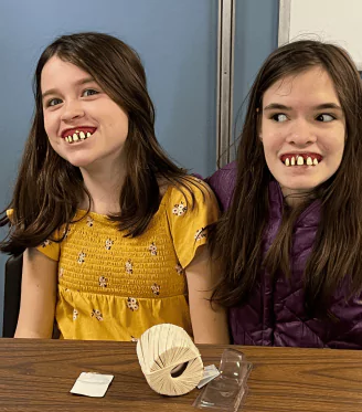 Little girls having fun with fake teeth